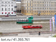 Москва, Россия. Два речных трамвайчика Рэдиссон, красный и зеленый, плывут по Москве реке в районе Балчуга и парка Зарядье на фоне красивых старых домов. (2023 год). Редакционное фото, фотограф Сергей Никифоров-Гордеев / Фотобанк Лори