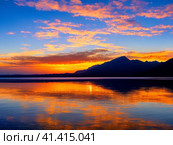 Beautiful sunset sky above clouds with dramatic light. Yellow, orange, red clouds above the horizon. Beautiful evening sky landscape. Sunset over the sea. Generated by artificial intelligence. Стоковое AI-изображение, AI-художник Юлия Петровская / Фотобанк Лори