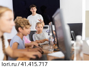Young male teacher speaking to underage attendees of computer courses. Стоковое фото, фотограф Яков Филимонов / Фотобанк Лори