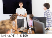 Young male teacher speaking to underage attendees of computer courses. Стоковое фото, фотограф Яков Филимонов / Фотобанк Лори