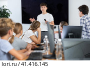 Young male teacher speaking to underage attendees of computer courses. Стоковое фото, фотограф Яков Филимонов / Фотобанк Лори