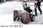 Snowblower removes snow, a man cleans the yard outside. Стоковое фото, фотограф Igor Skripachev / Фотобанк Лори