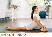 Experienced girl fitness club teacher performs pigeon asana, eka pada rajakapotasana. Стоковое фото, фотограф Яков Филимонов / Фотобанк Лори