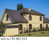 House of yellow brick and brown corrugated roof made of metal. Lattices on the windows. Стоковое фото, фотограф Леонид Еремейчук / Фотобанк Лори