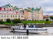 Экскурсионный катер в центре города. Бывший купеческий дом Векрута на заднем плане. Город Выборг Ленинградской области (2023 год). Редакционное фото, фотограф Румянцева Наталия / Фотобанк Лори