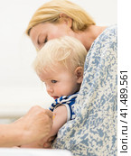 Child beeing vaccinated by pediatrician in presence of his mother. Preventive vaccination against Diphtheria, whooping cough, tetanus, hepatitis, haemophilus influenzae, pneumococcus, poliomyelitis. Стоковое фото, фотограф Matej Kastelic / Фотобанк Лори
