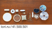 Accessories and supplies for bead embroidery: hoop with felt and mesh, sets of beads and beads, scissors, needles, monofilament and needle threader on a wooden table. Hobbies and handicrafts. Стоковое фото, фотограф Виктория Катьянова / Фотобанк Лори