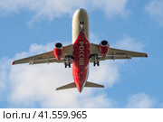 Пролетающий над головой самолет Сухой SuperJet 100-95B "Новый Уренгой" (RA-89051) авиакомпании "Россия" крупным планом (2023 год). Редакционное фото, фотограф Виктор Карасев / Фотобанк Лори