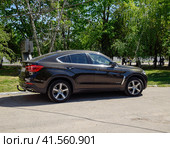 Black BMW X6 is parked in the park. A sports car of a premium cl (2017 год). Редакционное фото, фотограф Леонид Еремейчук / Фотобанк Лори