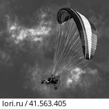 Black and white monochrome illustration of a flying motorized paraplane with people on a background of clouds. Illustration. Стоковая иллюстрация, иллюстратор Бузмакова Светлана / Фотобанк Лори