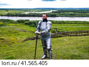 knight in armor stands against the background of native open spaces, forests and a river. Knightly armor and weapon. Стоковое фото, фотограф Леонид Еремейчук / Фотобанк Лори