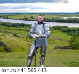 knight in armor stands against the background of native open spaces, forests and a river. Knightly armor and weapon. Стоковое фото, фотограф Леонид Еремейчук / Фотобанк Лори