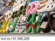 Nizhny Novgorod, Russia - May 29, 2023: felt shoes. Various variants of felted shoes with handmade embroidery. Souvenir products in the store. Редакционное фото, фотограф Оксана Медведева / Фотобанк Лори