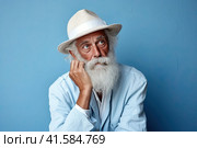 Portrait of an elderly man with a large gray beard and lush hair with a thoughtful look to the side. Blue background. Generated by AI. Стоковое AI-изображение, AI-художник Ярославский Максим / Фотобанк Лори