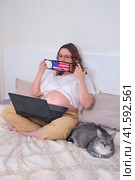 Happy pregnant woman donning n95 ffp2 medical mask with american flag. Education and home office work during a virus outbreak. Стоковое фото, фотограф Андрей Журавлев / Фотобанк Лори