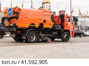 Orange bright road-washing water truck drives down the street of the city (2021 год). Редакционное фото, фотограф Константин Григорьев / Фотобанк Лори