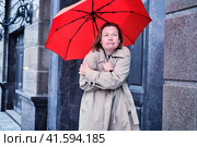 A woman with an umbrella freezes alone at the door of the house. Стоковое фото, фотограф Андрей Журавлев / Фотобанк Лори