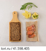 Red fish sandwich ingredients flatlay on a cement background. The products for burger tout, wholegrain bread, lemon, cheese, greens. Стоковое фото, фотограф Воловодов Владимир / Фотобанк Лори