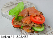 Redfish bread snack with salad, vegetables and herbs laying on a white rustic board. Стоковое фото, фотограф Воловодов Владимир / Фотобанк Лори