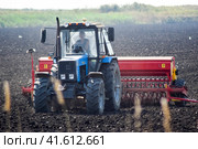 Tractor with a seeder in the field. sowing seeds in the soil. Стоковое фото, фотограф Леонид Еремейчук / Фотобанк Лори