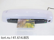 A machine for laminating photos and documents with plastic. Desktop white laminator, close-up. Стоковое фото, фотограф Андрей Журавлев / Фотобанк Лори