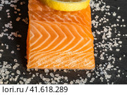 Top view of fresh raw salmon fish steak with spices on a dark stone background. Salt, spices, seasonings and other ingredients. Стоковое фото, фотограф Артем Лукин / Фотобанк Лори