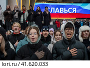 Молодые люди, члены Движение первых поют национальный гимн России во время репетиции музыкального спектакля "1000 первых", который должен состояться в День народного единства во время проведения выставки-форума Россия на ВДНХ в городе Москве, Россия (2023 год). Редакционное фото, фотограф Николай Винокуров / Фотобанк Лори