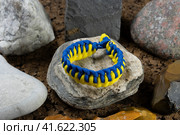 Braided paracord bracelet on the background of stones. Handmade, creative design. Стоковое фото, фотограф Артем Лукин / Фотобанк Лори
