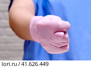 Doctor in protective gloves shows a vulgar gesture of a fig sign, closeup. Стоковое фото, фотограф Андрей Журавлев / Фотобанк Лори