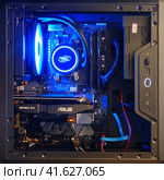 Open computer system unit with neon blue light water cooling - Moscow, Russia, December 23, 2020. Редакционное фото, фотограф Андрей Журавлев / Фотобанк Лори