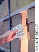 Man takes medicine pills from a warehouse at night. Стоковое фото, фотограф Андрей Журавлев / Фотобанк Лори