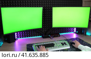 Two computer monitors with green screen mockup. A man typing text. Стоковое видео, видеограф Антон Колмаков / Фотобанк Лори