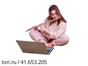 Cute woman flutist plays a musical instrument, isolated on a white background. Online learning, music lessons via laptop. Стоковое фото, фотограф Андрей Журавлев / Фотобанк Лори