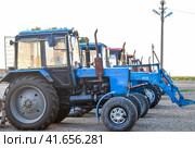 Tractor, standing in a row. Agricultural machinery. (2015 год). Редакционное фото, фотограф Леонид Еремейчук / Фотобанк Лори