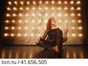 The woman flutist musician, was basking in the bright lights of the concert during her musical performance. Стоковое фото, фотограф Андрей Журавлев / Фотобанк Лори