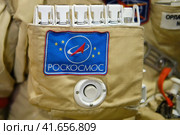 The emblem of Roscosmos on the suit of the astronaut with the ISS. Roscosmos inscription - text on a space suit. Exhibition Days of the far East - Moscow, Russia, 12 13 2019. Редакционное фото, фотограф Андрей Журавлев / Фотобанк Лори
