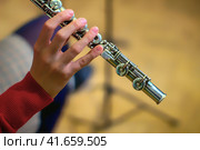 The girl is holding a large concert flute (in hands close-up). Professional musician at the rehearsal. A woman plays the transverse flute. Стоковое фото, фотограф Андрей Журавлев / Фотобанк Лори