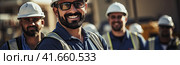 A confident and smiling staff of factory workers, engineers, managers and foremen stands on the territory of the heavy industry production plant. Generated by AI. Стоковое AI-изображение, AI-художник Ярославский Максим / Фотобанк Лори