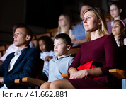 mother, father and their children sitting at perfomance in theatrical auditorium. Стоковое фото, фотограф Яков Филимонов / Фотобанк Лори