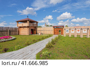 Клязьминский городок (Стародуб), Владимирская область, Россия. Август 2023 года. Зеленая территория музея «Стародуб на Клязьме» со стилизованной бревенчатой сторожевой башней и забором из кольев. Редакционное фото, фотограф Сергей Никифоров-Гордеев / Фотобанк Лори