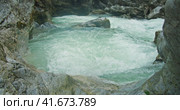 Cold mountain river with clear glacial water flows in a rocky gorge. Spring nature landscape in Alps. Стоковое видео, видеограф Igor Tichonow / Фотобанк Лори