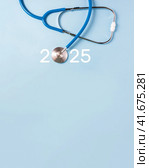 Medicine stethoscope and numbers 2025 on blue background. Happy New Year medical calendar cover. Vertical poster, copy space. Стоковое фото, фотограф Клара Мухаметзянова / Фотобанк Лори