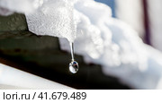 A drop of melted snow falls from the roof. Стоковое фото, фотограф Igor Skripachev / Фотобанк Лори