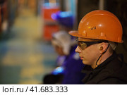 Workers fitters and welders in protective clothing and a helmet. Working in the operating industrial facilities. Стоковое фото, фотограф Леонид Еремейчук / Фотобанк Лори