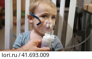 Sick Baby Girl with making Inhalation with a Mask on his Face sitting in Living Room at Home. Children Healing. Child Inhalation therapy with Compressor nebulizer. Inhaling fumes medication into lung. Стоковое видео, видеограф Марина Демидюк / Фотобанк Лори