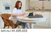 A person who is passionate about music is taking an online flute lesson with her tutor in her home kitchen while using her phone to record the session for future reference. Стоковое видео, видеограф Андрей Журавлев / Фотобанк Лори