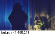The shadow of a female figure holds her head with her hands against the background of a window curtain, stop motion. A woman stands grieving at the night dark window, the silhouette is low key. Стоковое видео, видеограф Андрей Журавлев / Фотобанк Лори