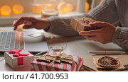 Female buyer makes order on laptop. Woman picking gifts online purchases at cozy home among gift boxes and packages. Winter sales, Black Friday. Christmas discount promotions. Blurred bokeh light. Стоковое видео, видеограф Марина Демидюк / Фотобанк Лори