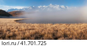 Beautiful sunny foggy morning in the mountains. Autumn frost on dry grass. Snowy peaks. North Chuysky Range and Lake Dzhangyskol. Russia, Altai Republic. Panoramic view. Стоковое фото, фотограф Саблин Станислав / Фотобанк Лори