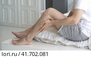 The man's calf muscle cramped, massage of male leg at home, self-soothing massaging. Стоковое видео, видеограф Станислав Тарко / Фотобанк Лори